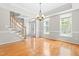 Sunlit dining room featuring hardwood floors, staircase access, and modern chandelier at 203 Worsham Dr., Chapel Hill, NC 27516