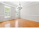 Bright dining area showcasing hardwood floors, two windows, and modern lighting at 203 Worsham Dr., Chapel Hill, NC 27516