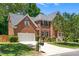 Charming brick home featuring a well-maintained lawn, mature trees, and an attached two-car garage at 203 Worsham Dr., Chapel Hill, NC 27516