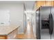 Hallway view featuring tile floors, neutral paint, access to multiple rooms, and a stainless steel refrigerator at 203 Worsham Dr., Chapel Hill, NC 27516