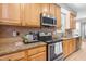 Contemporary kitchen featuring granite counters, stainless appliances, and warm maple cabinets at 203 Worsham Dr., Chapel Hill, NC 27516
