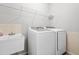 Laundry room featuring modern white washer and dryer, utility sink, and white wire rack shelving at 203 Worsham Dr., Chapel Hill, NC 27516