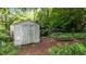 Exterior view of the backyard shed, offering additional storage space and surrounded by lush greenery at 205 W Oak Ave, Wake Forest, NC 27587