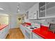 Functional kitchen design with white appliances, red countertops, and ample cabinet storage for organization at 205 W Oak Ave, Wake Forest, NC 27587