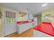 Bright kitchen featuring white cabinets, red countertops, and a door leading to the outdoor space at 205 W Oak Ave, Wake Forest, NC 27587