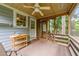 Inviting screened porch perfect for outdoor relaxation, featuring a ceiling fan and wooded views at 205 W Oak Ave, Wake Forest, NC 27587