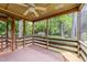 Relaxing screened porch with ceiling fan, offering tranquil views of the surrounding greenery at 205 W Oak Ave, Wake Forest, NC 27587