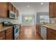 Open kitchen with granite counters, stainless appliances, and view to the backyard at 2082 Weston Green Loop Loop, Cary, NC 27513