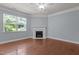 Light-filled living room with hardwood floors, fireplace, and large window offering natural light at 2082 Weston Green Loop Loop, Cary, NC 27513