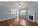 Bright living room with hardwood floors, fireplace, and large windows at 2082 Weston Green Loop Loop, Cary, NC 27513