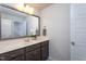 Neutral bathroom with a sink, cabinets, decorative mirror, and a tiled floor at 228 Shingle Oak Rd, Wake Forest, NC 27587