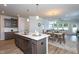 Well-lit open concept shows the kitchen with a quartz countertop island flowing into the dining and living space at 228 Shingle Oak Rd, Wake Forest, NC 27587