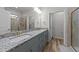 Bright bathroom featuring double vanity with granite countertop, wood-look tile flooring, and glass shower at 24 W Catalina Ct, Clayton, NC 27527