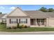 Charming single-story home featuring manicured lawn and inviting front porch with stone accents and comfortable seating at 24 W Catalina Ct, Clayton, NC 27527