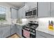 Close up of the kitchen area featuring stainless steel appliances, light gray cabinets, and white subway tile backsplash at 24 W Catalina Ct, Clayton, NC 27527