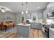 Open kitchen and dining area with stainless steel appliances, gray cabinetry, island, and wood floors at 24 W Catalina Ct, Clayton, NC 27527