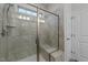 Tiled shower featuring glass door, built-in bench, shower head and window at 24 W Catalina Ct, Clayton, NC 27527