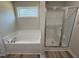 Bathroom featuring a soaking tub under a window, and glass enclosed shower at 240 Eason Creek Way, Clayton, NC 27527