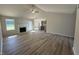 Bright open concept living room featuring hardwood floors, a fireplace, ceiling fan, and natural light at 240 Eason Creek Way, Clayton, NC 27527