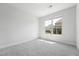 Empty bedroom with neutral carpet and natural light streaming through the window at 241 Fishburn Dr, Apex, NC 27523