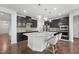 Well-appointed kitchen with a large island, modern appliances, dark wood cabinets, and stylish pendant lighting at 241 Fishburn Dr, Apex, NC 27523