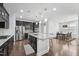 Modern kitchen with granite countertops, dark cabinetry, stainless steel appliances, and a central island at 241 Fishburn Dr, Apex, NC 27523