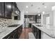 Gourmet kitchen features stainless steel appliances, granite counters, mosaic backsplash, and rich dark cabinetry at 241 Fishburn Dr, Apex, NC 27523