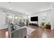 Bright living room with hardwood floors, large windows, a comfortable gray sofa, and stylish decor at 241 Fishburn Dr, Apex, NC 27523