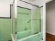 This bathroom features vintage green tiling, a shower with a sliding glass door, and a grab bar at 2434 Morningside Dr, Burlington, NC 27217