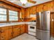 Bright kitchen with knotty pine cabinets, stainless steel refrigerator, and white appliances at 2434 Morningside Dr, Burlington, NC 27217