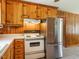 Knotty pine cabinets provide lots of storage in this kitchen with updated stainless steel refrigerator at 2434 Morningside Dr, Burlington, NC 27217