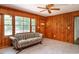Comfortable living room with wood-paneled walls, a ceiling fan, and large windows overlooking the yard at 2434 Morningside Dr, Burlington, NC 27217