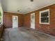 Enclosed porch with brick walls, concrete floor, and access to a yard or patio at 2434 Morningside Dr, Burlington, NC 27217