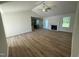 Open-concept living room with high ceilings, ceiling fan, wood flooring, and view into kitchen at 245 Eason Creek Way, Clayton, NC 27527