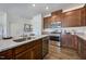 Modern kitchen featuring wood cabinets, stainless steel appliances, granite countertops, and hardwood floors at 253 Hank Way, Angier, NC 27501