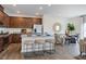 Open-concept kitchen with wood cabinets, stainless steel appliances, granite counters, and island with seating at 253 Hank Way, Angier, NC 27501