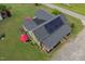 Aerial view of the house with solar panels, manicured lawn, landscaping and nearby road at 2646 Laurel Mill-Centerville Rd, Louisburg, NC 27549