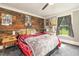 Cozy bedroom featuring a wood accent wall, comfortable furnishings, and ample natural light at 2646 Laurel Mill-Centerville Rd, Louisburg, NC 27549