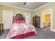 Comfortable bedroom with decorative headboard, dresser, and access to bathroom through an open doorway at 2646 Laurel Mill-Centerville Rd, Louisburg, NC 27549