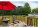 Wooden deck with seating and a red umbrella, perfect for relaxing and entertaining guests at 2646 Laurel Mill-Centerville Rd, Louisburg, NC 27549