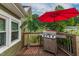Outdoor deck featuring a stainless steel grill and a red umbrella for shade at 2646 Laurel Mill-Centerville Rd, Louisburg, NC 27549