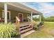 Inviting front porch featuring beautiful flowerpots and a red door, perfect for relaxing outdoors at 2646 Laurel Mill-Centerville Rd, Louisburg, NC 27549