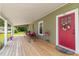 Inviting front porch with a swing and a vibrant red front door adorned with a colorful wreath at 2646 Laurel Mill-Centerville Rd, Louisburg, NC 27549