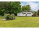 Two-car garage with white doors surrounded by a lush green lawn and mature trees at 2646 Laurel Mill-Centerville Rd, Louisburg, NC 27549