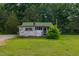 Rustic outbuilding surrounded by lush greenery and mature trees at 2646 Laurel Mill-Centerville Rd, Louisburg, NC 27549