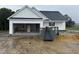 New construction home featuring white siding, dark roof, attached garage, and construction dumpster at 2760 Rains Mill Rd, Princeton, NC 27569