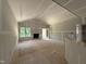 Spacious living room with fireplace, abundant natural light, and unfinished floors at 2760 Rains Mill Rd, Princeton, NC 27569