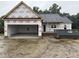 Exterior of a new home under construction with an attached garage and a dumpster for waste removal at 2776 Rains Mill Rd, Princeton, NC 27569