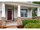 Cozy front porch with stone pillars and an inviting deep red front door at 2855 Wilkes Lake Dr, Fuquay Varina, NC 27526