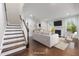 Open-concept living room featuring wood floors, a modern fireplace, and stairs to upper level at 2855 Wilkes Lake Dr, Fuquay Varina, NC 27526